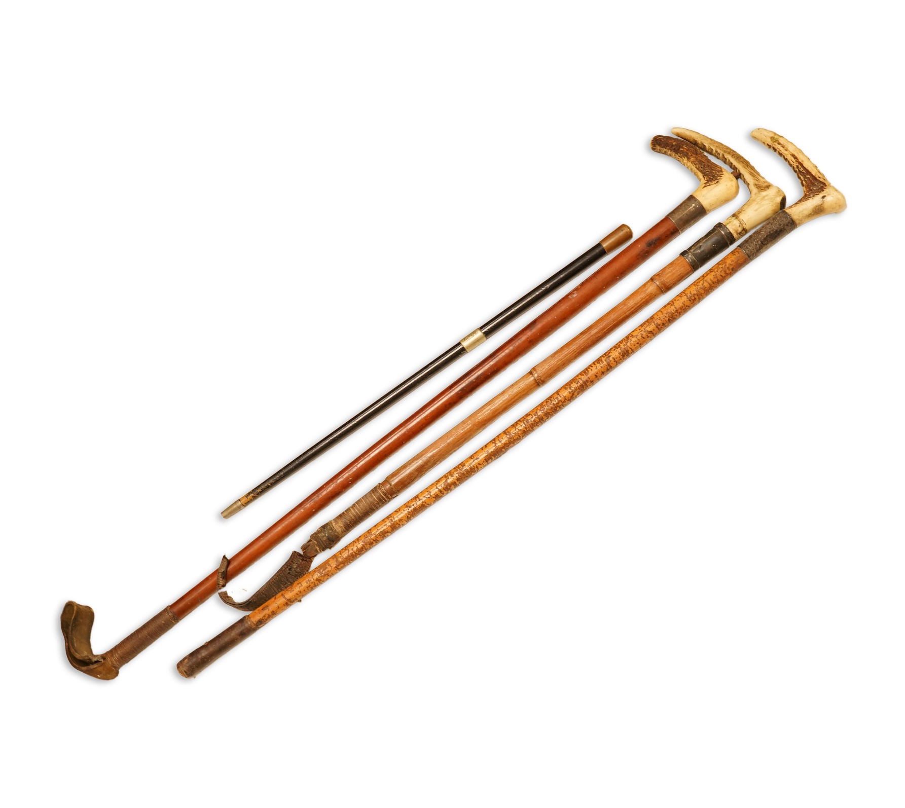 Three early 20th century antler handles riding crops with silver mounts and a swagger stick engraved Louise Martin, 1919